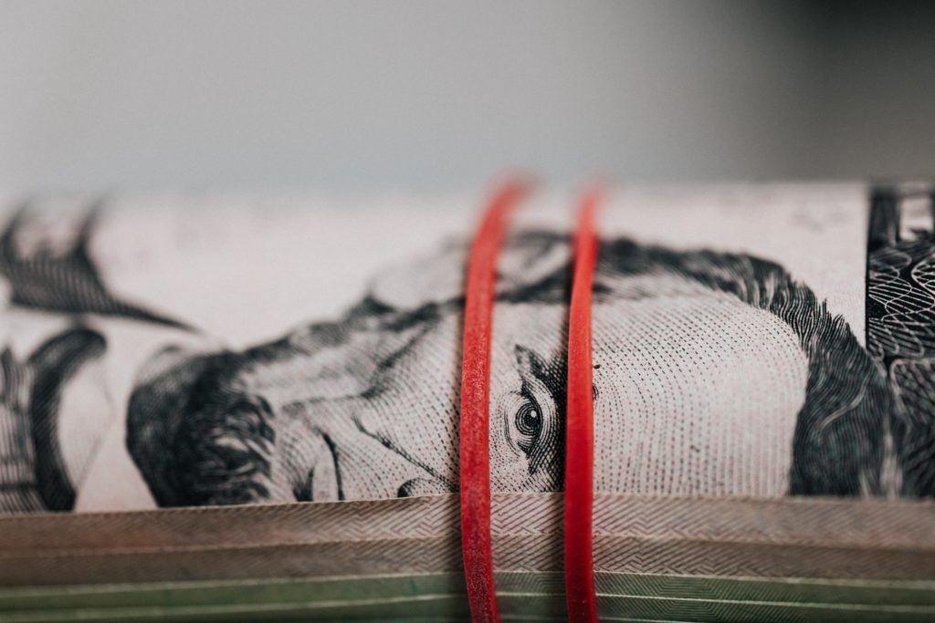 ASV dolāru rullis, kam apliktas divas gumijas. Starp šīm gumijām ir  redzama uz šīm banknotēm attēlotā ASV prezidenta Abrahama Linkolna acs.